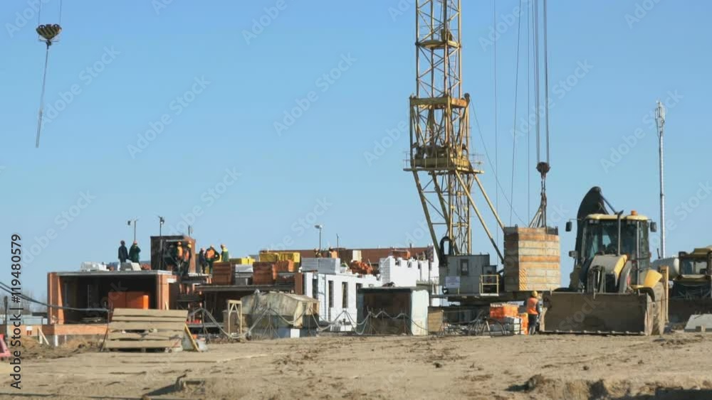 Workers work on construction of building outdoors Workers work on construction of building outdoors