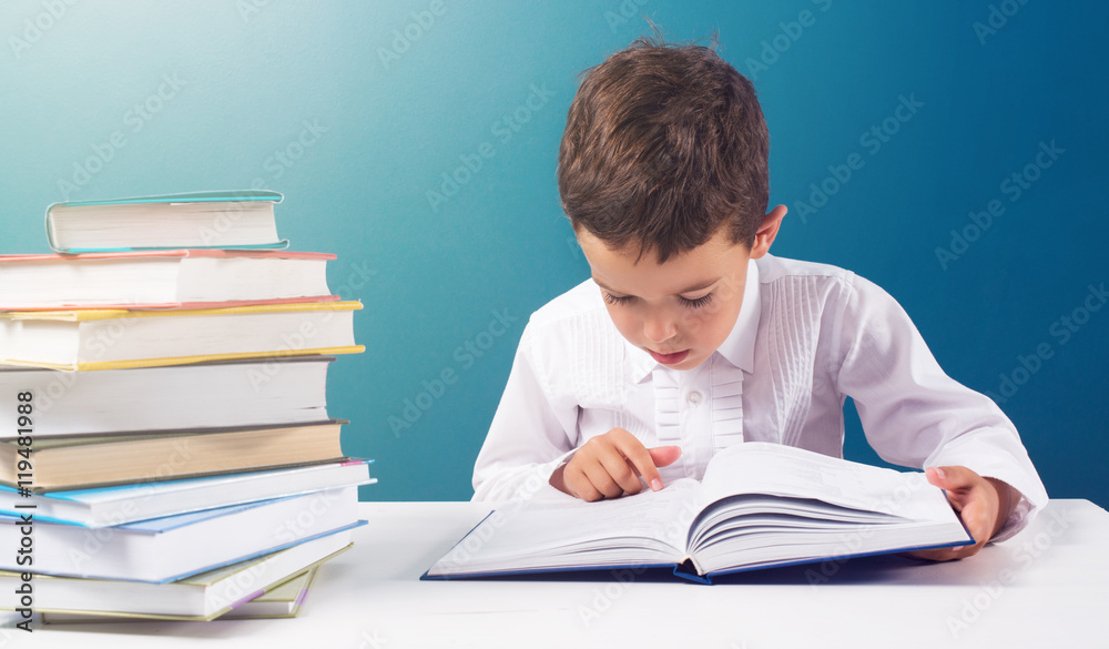 Сute boy reading book at the table Сute boy reading book at the table