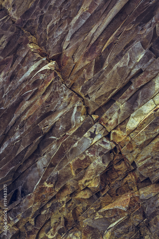 Ferric basalt rock strata closeup. Rusty rock layers pattern.