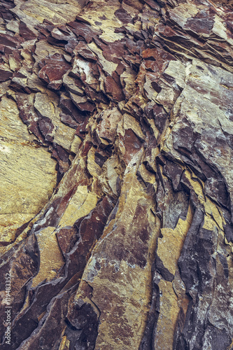 Ferric rock strata closeup. Rusty rock layers background.