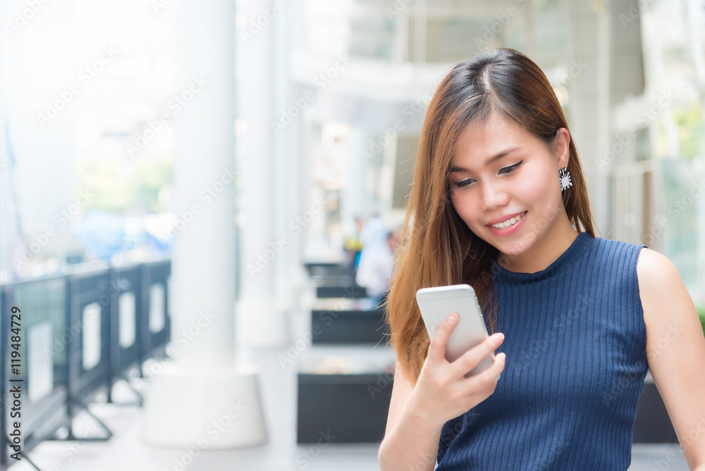 Beautiful young Asian woman texting on the phone Beautiful young Asian woman texting on the phone