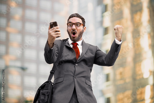 Ecstatic happy executive sales businessman cheering excited in celebration after good news photo