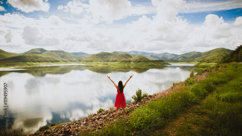 Bild auf Leinwand woman on a summit with upraised arms on the top mountain with th