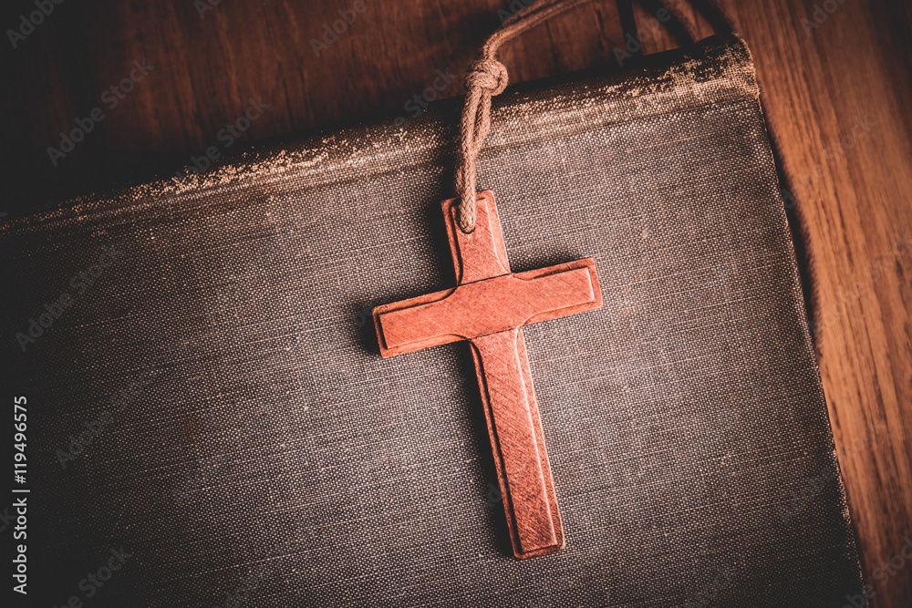 Image of wooden cross on bible background