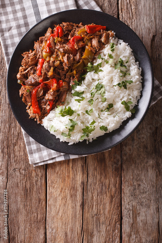 ropa vieja: beef stew in tomato sauce with vegetables and rice garnish. Vertical top view
