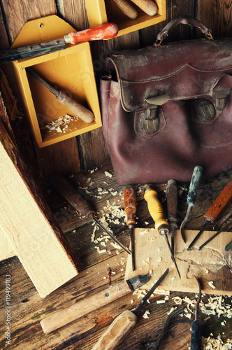 Chisels and carved piece of wood in traditional carpenter worksh photo