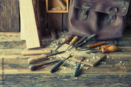 Chisels and carved piece of wood in traditional carpenter worksh photo