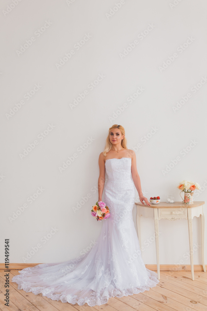 Portrait of a beautiful blonde bride with bouquet in an interior light, wedding concept Portrait of a beautiful blonde bride with bouquet in an interior light, wedding concept