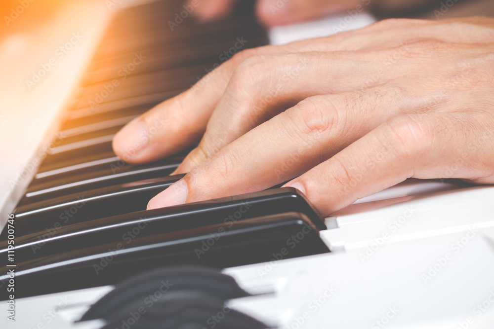 Fototapeta premium hands playing on piano keys for music background