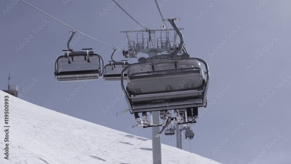 Ski resort. Ski lifts with snowboarders and skiers. Height. White mountains. Sunny day. Extreme. Slow motion Ski resort. Ski lifts with snowboarders and skiers. Height. White mountains. Sunny day. Extreme. Slow motion