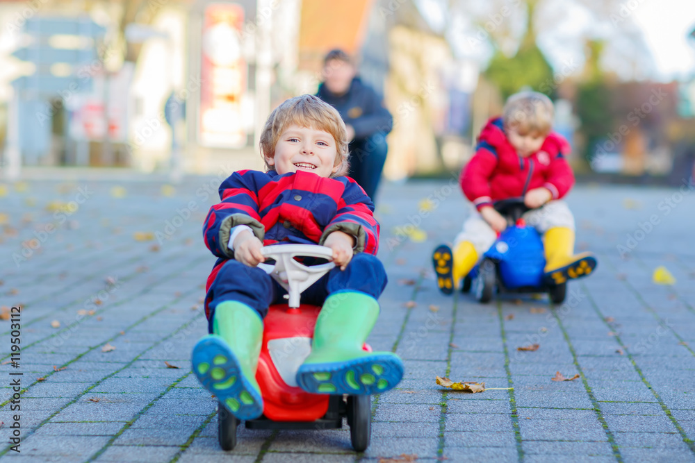 Two little kids boys and father playing with cars, outdoors Two little kids boys and father playing with cars, outdoors