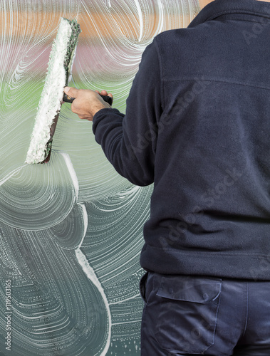 window cleaner using a squeegee to wash a window