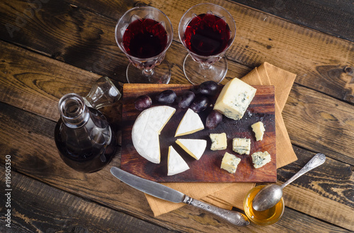 Cheese plate with grape and wine on wood photo