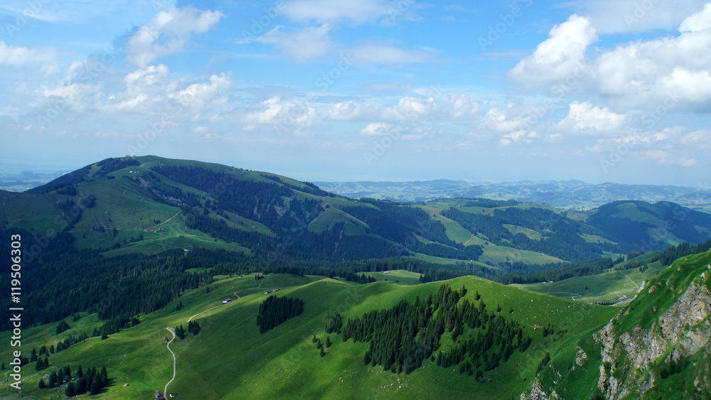 Landschaft in der Schweiz, bewaldete Berge und Täler, Wälder und Wiesen, blauer Himmel und weiße Wolken/Landschaft in der Schweiz