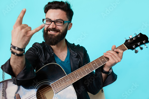 Schilderij op canvas Happy young punk rocker with a guitar and dark sunglasses