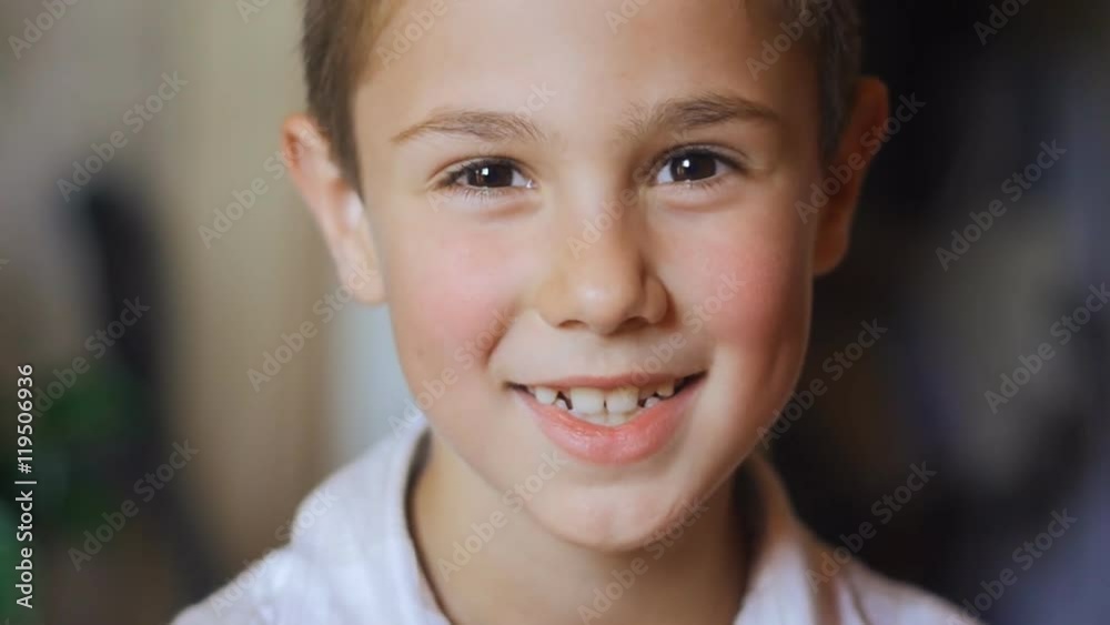 portrait of 8 year old boy with big eyes smiling at the camera in slow-motion portrait of 8 year old boy with big eyes smiling at the camera in slow-motion