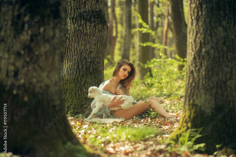 Young woman with goat in forest