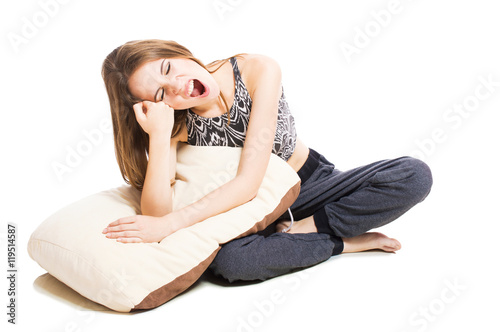 Artistic young girl with a pillow isolated on white background.