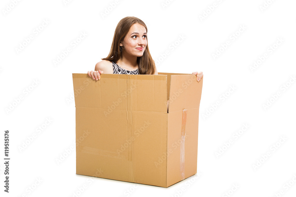 Young funny girl sitting in a big box isolated on white background. Young funny girl sitting in a big box isolated on white background.