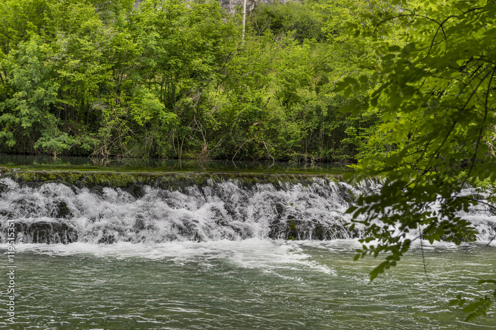 Obraz premium small waterfall on a wide river, dam