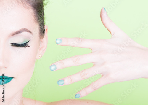 Close-up of professional green make-up with matching nails