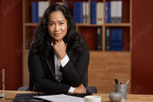 Quadro em tela Portrait of smiling Indonesian business lady at her table