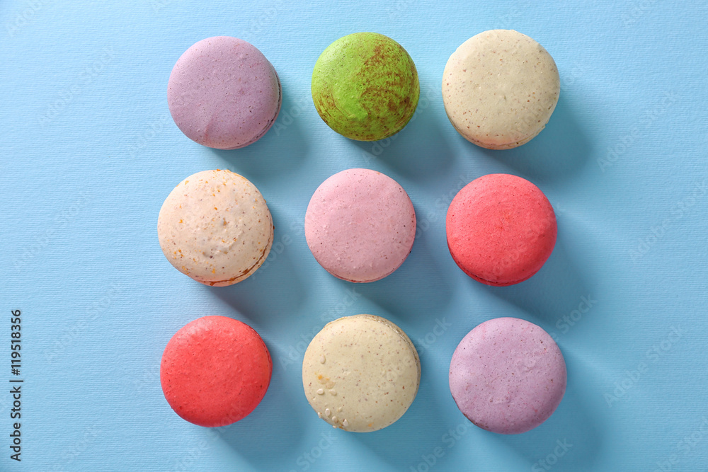 Colorful tasty macaroons in row on light blue background Colorful tasty macaroons in row on light blue background