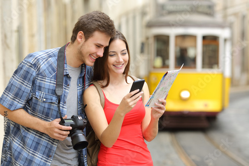 Couple of tourists consulting guide online photo