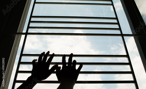 Silhouette of hands hold the window, sky background. photo