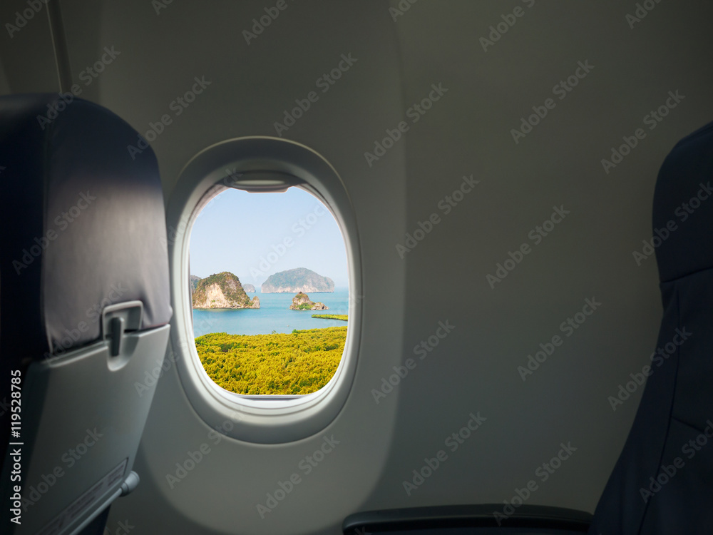 Island, sea and mountain view from window of airplane. Travel, vacation and journey concept.