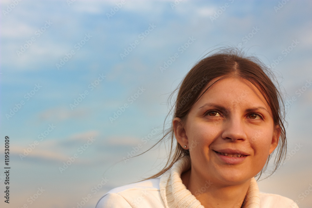 Smiling woman. Emotional portrait of beautiful brunette at sunset. Sunny windy evening Smiling woman. Emotional portrait of beautiful brunette at sunset. Sunny windy evening