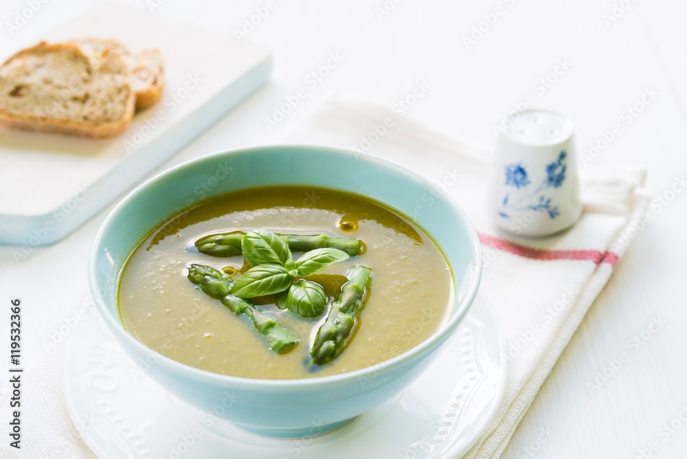 Asparagus soup in a bowl topped with fresh basil Asparagus soup in a bowl topped with fresh basil