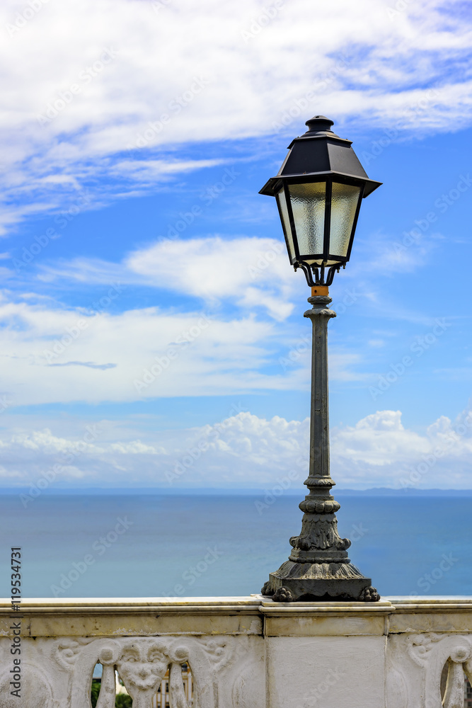Urban Lampposts on ancient wall with the sea in the background in the city of Salvador, Bahia