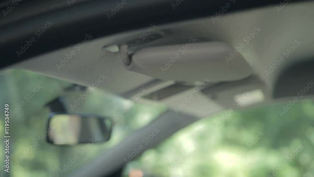 Woman hiding ignition key in car sun visor Woman hiding ignition key in car sun visor