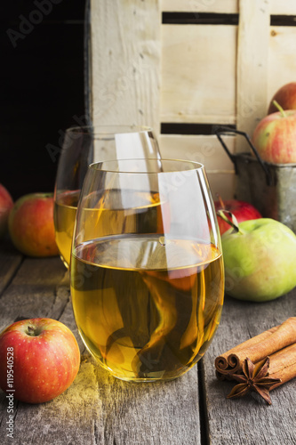 Apple juice in glasses on a wooden background