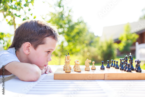 young chess player outdoors. the boy concentrating on the game of chess. view profile