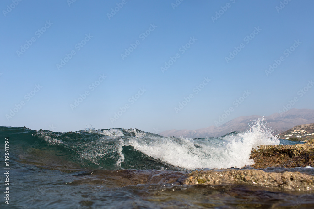 Sea Wave and foam on a background of mountains