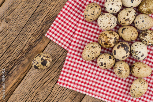 quail eggs on a red napkin on old wooden table.