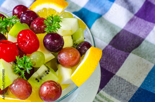 Bowl of healthy fresh fruit salad on pattern of Thai hand made fabric background