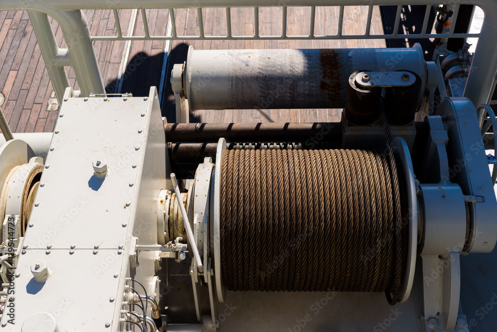 Large spool with steel wire on a tugging winch on a ship. Large spool with steel wire on a tugging winch on a ship.