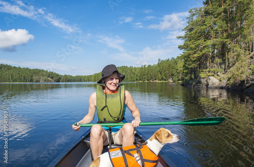 Woman canoeing with dog at lake