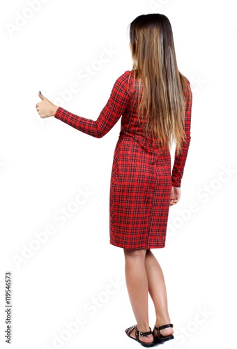 Back view of woman thumbs up. girl in red plaid dress shows thumb up.