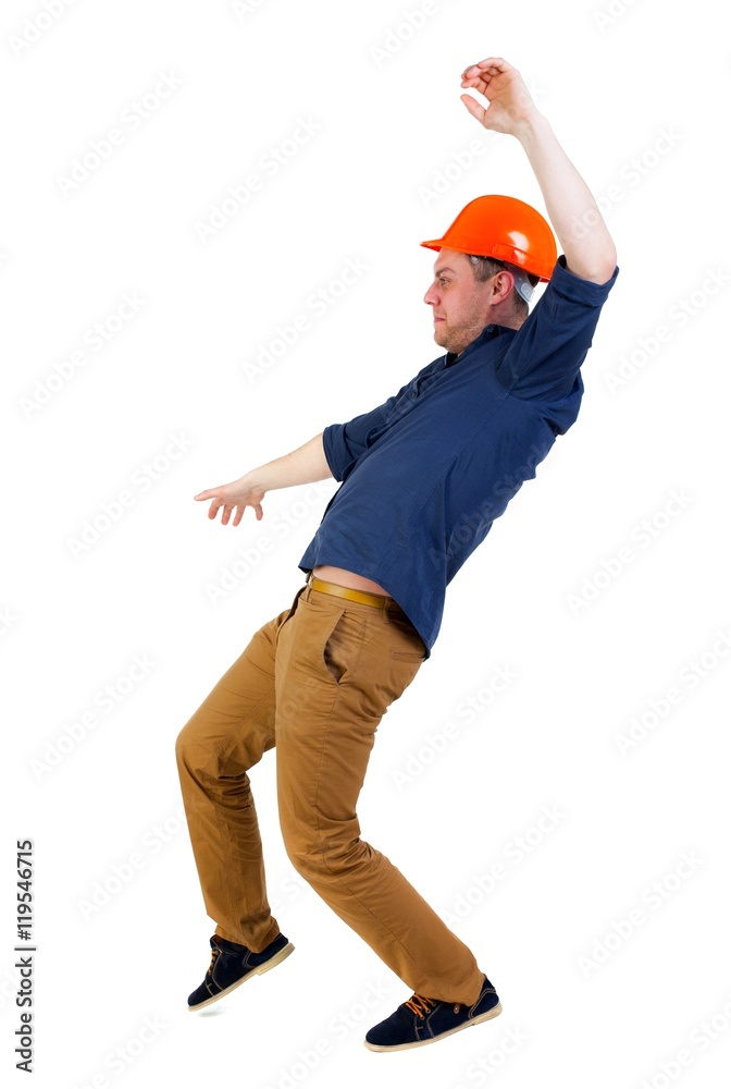 Balancing young man. or dodge the falling man. worker in construction helmet falls. Engineer in protective helmet falls slipping