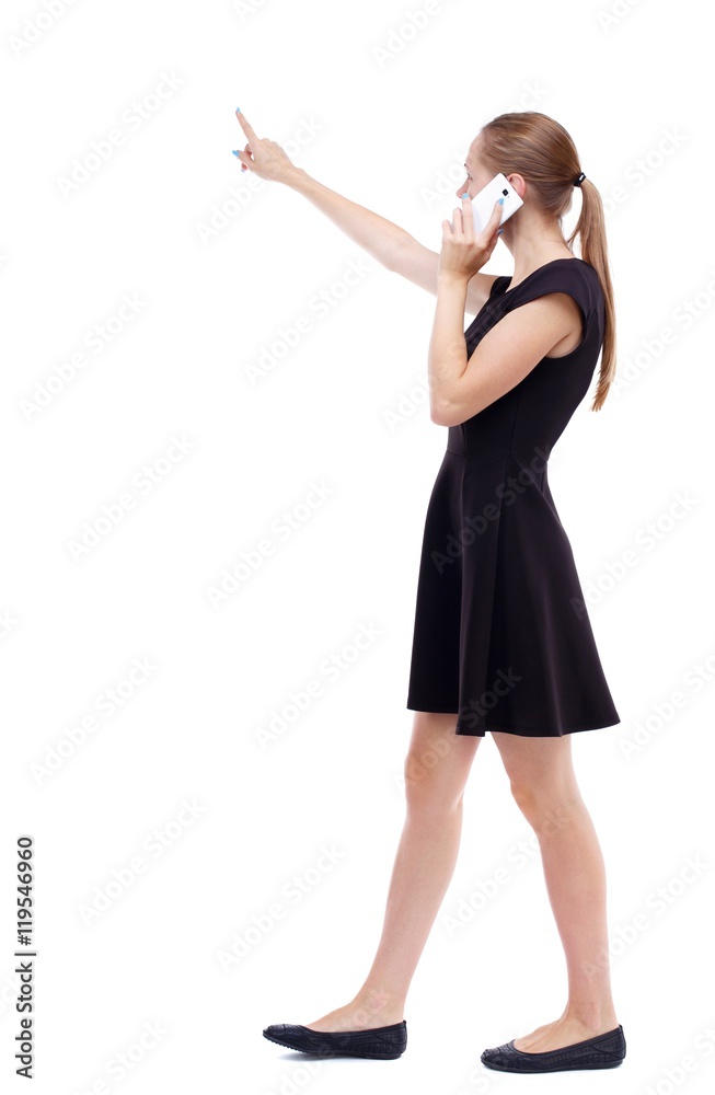 side view of walking woman. Rear view people collection. Isolated over white background. Blonde in a short black dress talks on the phone about what I heard. side view of walking woman. Rear view people collection. Isolated over white background. Blonde in a short black dress talks on the phone about what I heard.