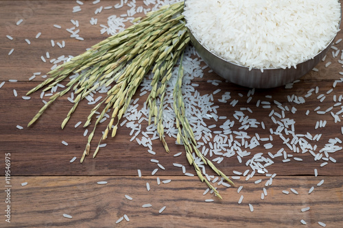 Thai jasmine rice in metal bowl with background of wooen table. photo