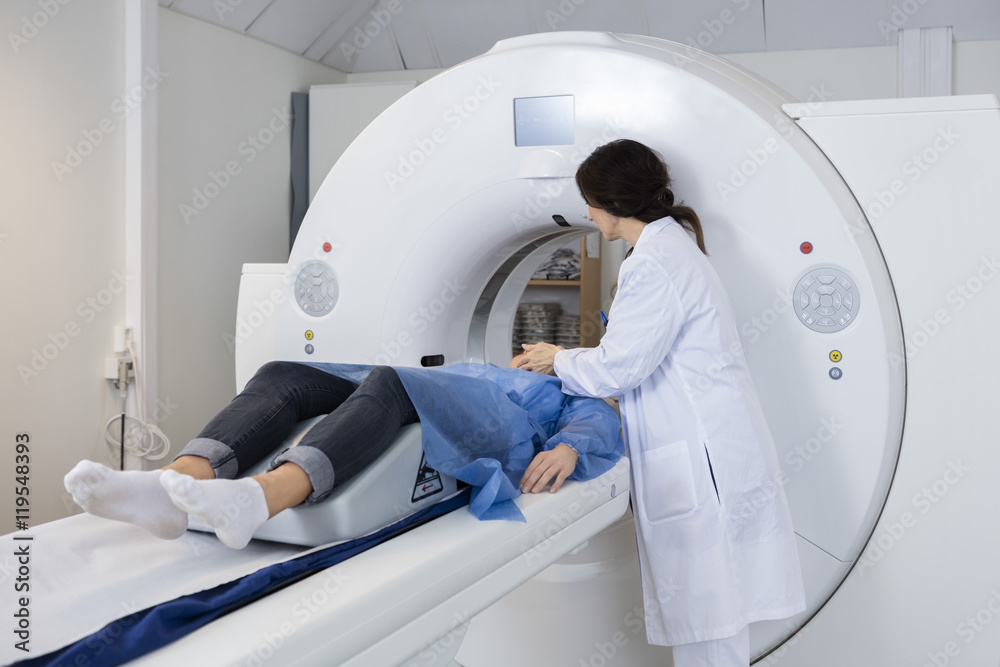 Female Doctor Preparing Patient For CT Scan Female Doctor Preparing Patient For CT Scan