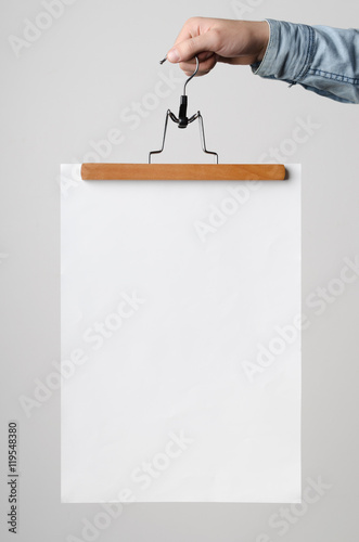 Принти на полотні A3 Poster Mock-Up - Man holding a poster on a clothes hanger on a white background