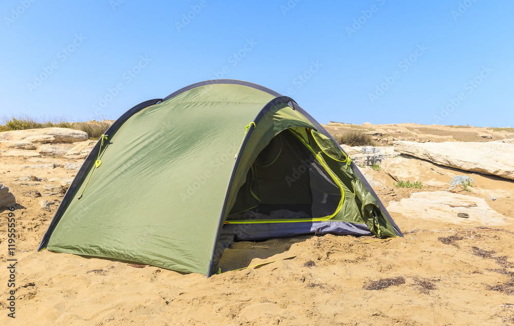Tourist tent disintegrated on the rocky shore