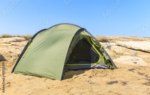 Tourist tent disintegrated on the rocky shore