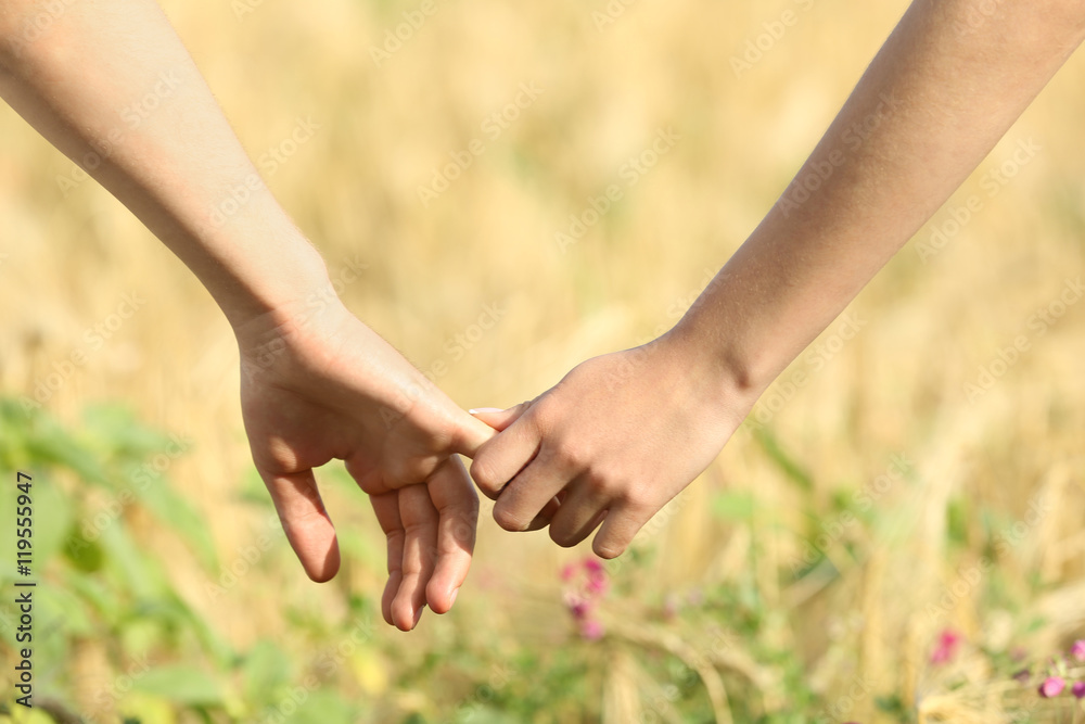 Young couple holding hands on beautiful field Young couple holding hands on beautiful field